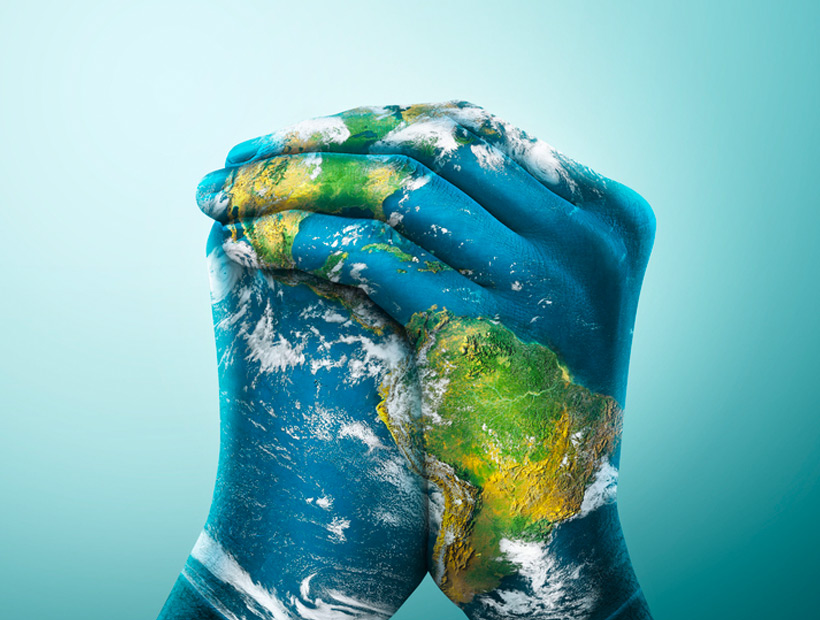 A close-up of multiple pairs of hands clasped in prayer, symbolizing unity and devotion in a serene setting.